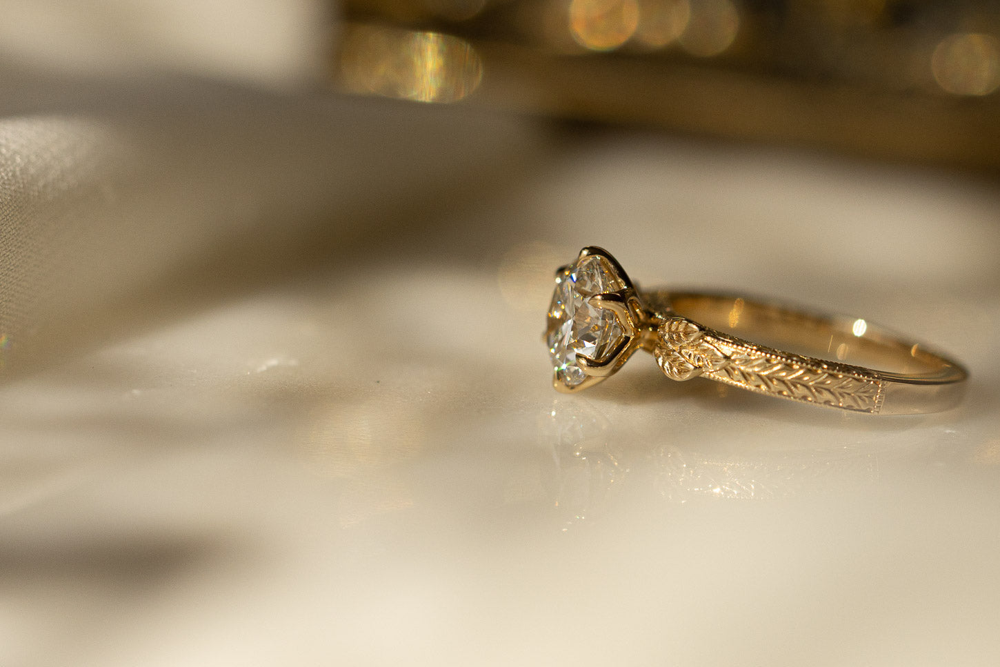 Diamond and 14k gold hand-engraved ring on a light background