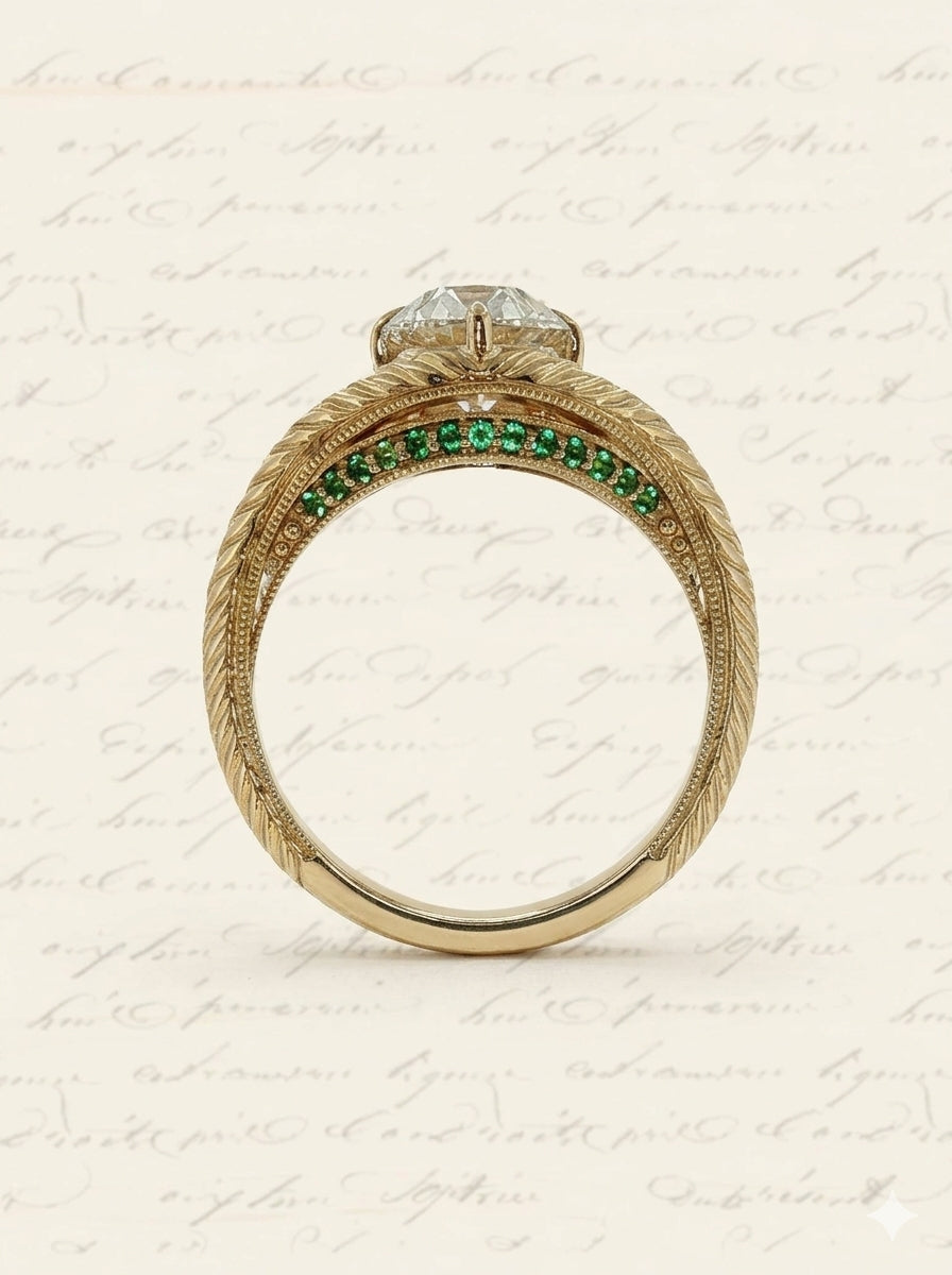 Side view of a Moonryvr engagement ring with a yellow gold, old-world, hand engraved, split shank band. The center stone is an old mine cut diamond with four claw prongs in a compass setting. The split shank has a hidden halo made of emeralds on the lower profile of the side view.